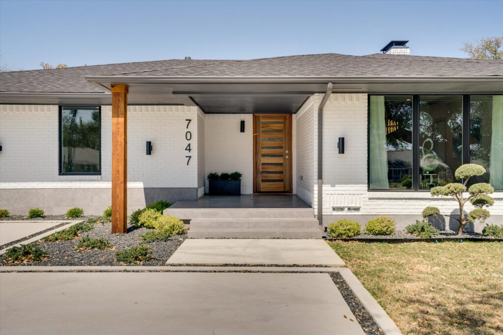 Royal Lane, Modern single-story white house with dark roof, large windows, landscaped yard