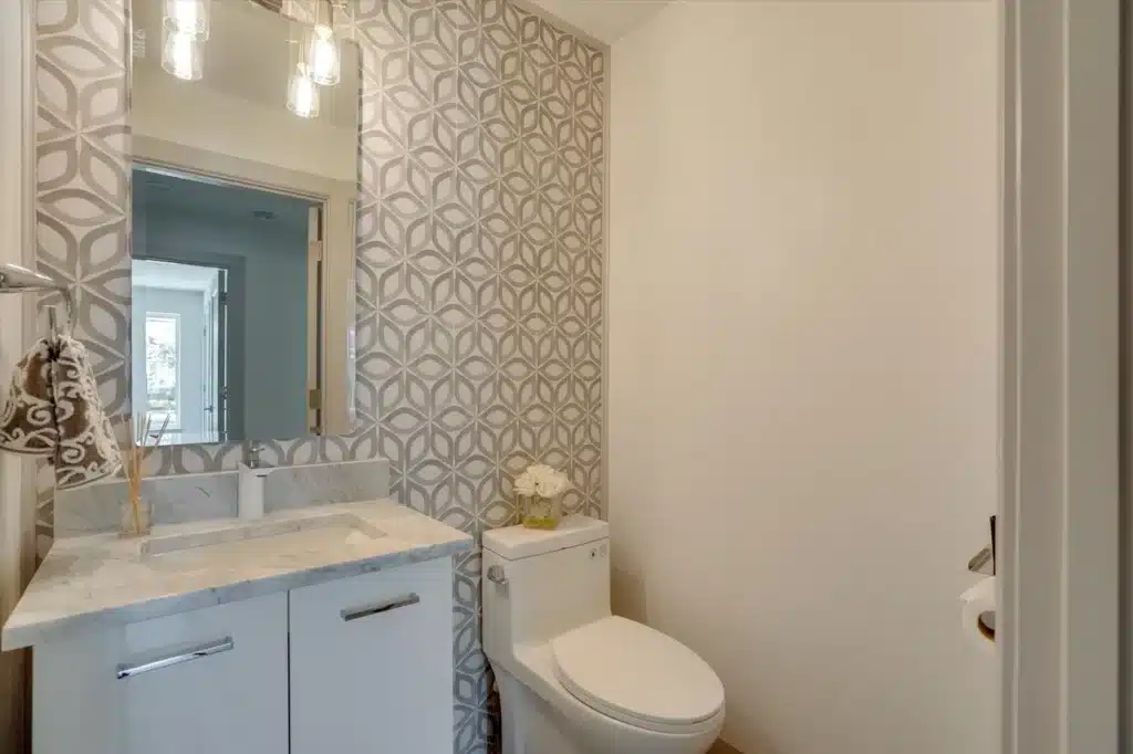 Modern bathroom with freestanding tub, glass shower, plants, towel, and open closet.