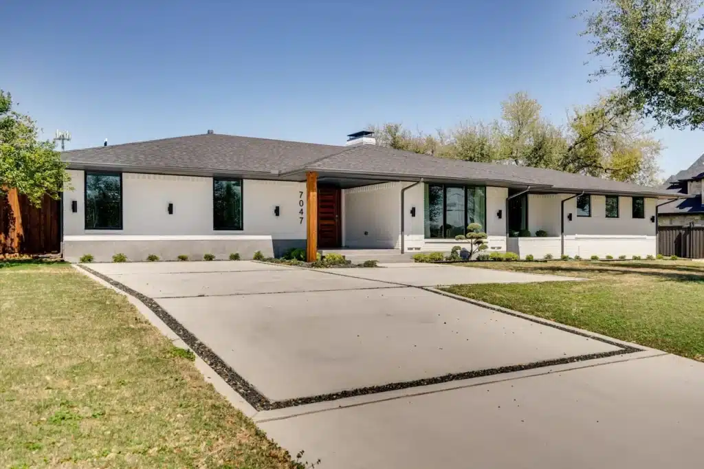Royal Lane, Modern single-story white house with dark roof, large windows, landscaped yard
